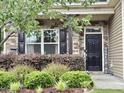 Charming front porch with stone detailing, black shutters and lush greenery for a warm welcome at 2511 Kestrel Heights Ct Ct, Durham, NC 27703