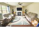 Inviting living room with a fireplace, large windows, hardwood floors, and stylish furnishings at 2511 Kestrel Heights Ct Ct, Durham, NC 27703