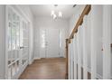 Bright foyer features wood floors, a staircase, and a view of the front door and french doors at 257 North Maple Walk Dr # 218, Garner, NC 27529