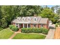 Traditional red brick home with manicured landscaping, dormer windows, and a long driveway at 2608 York Rd, Raleigh, NC 27608