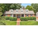Traditional brick home with white columns, dormer windows, and manicured landscaping at 2608 York Rd, Raleigh, NC 27608