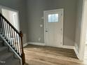 New entryway featuring vinyl wood flooring, a white door, and an open staircase at 268 Busterfield Ct, Benson, NC 27504