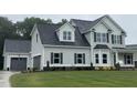 Charming two-story home with gray siding, a dark roof, and an attached two car garage at 268 Busterfield Ct, Benson, NC 27504