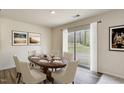 Elegant dining room featuring a wooden table, seating for six, and sliding glass doors at 2700 Barrington Dr, Raleigh, NC 27610