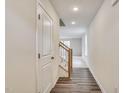 Long hallway with wood floors, leading to a staircase and a bright living area at 2700 Barrington Dr, Raleigh, NC 27610
