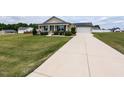 Lovely home showcasing the well-maintained lawn and a long driveway to the garage at 286 Beaver Tavern Dr, Benson, NC 27504