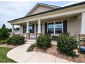 Inviting front porch with stone-clad columns and a cozy seating area at 286 Beaver Tavern Dr, Benson, NC 27504