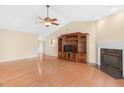 Open-concept living room featuring hardwood floors, fireplace, entertainment center, and a ceiling fan at 3027 Maple Ave # A-1, Burlington, NC 27215