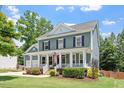 Charming two-story home with a welcoming front porch and landscaped yard provides inviting curb appeal at 309 Larkhaven Pl, Apex, NC 27539