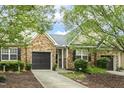 Charming home featuring a stone facade, a two-car garage, and lush landscaping at 309 Plank Bridge Way, Morrisville, NC 27560