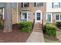 Townhouse exterior features a brick facade, bay window, and landscaped entrance with brick steps at 310 Bay Dr, Cary, NC 27511