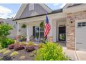 A relaxing front porch with a patriotic touch, featuring an American flag, plants, and cozy seating at 40 Bourne Dr, Franklinton, NC 27525