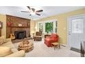 Cozy living room with brick fireplace, ceiling fan, and a bay window view at 4004 Bamburgh Ln, Apex, NC 27539
