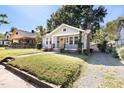 View of a well-maintained single-story home boasting a bright yellow door and traditional architectural details at 409 N Hyde Park Ave, Durham, NC 27703