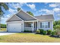 Single-Gathering home with a two-car garage, landscaped lawn, and covered front porch at 41 Tan Oak Dr, Selma, NC 27576