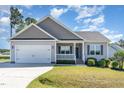 Single-Gathering home with a two-car garage, landscaped lawn, and covered front porch at 41 Tan Oak Dr, Selma, NC 27576