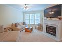 Bright living room features a cozy fireplace, neutral tones, and large windows offering natural light at 5113 Lady Of The Lake Dr, Raleigh, NC 27612