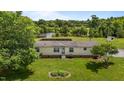 A front yard with flower bed leading up to a one story home with mature trees and partial lake view at 5200 Mrs Fuller Rd, Mebane, NC 27302