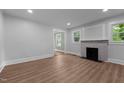 Open living room features beautiful wood floors, fireplace, and updated paint at 601 Acorn St, Burlington, NC 27215