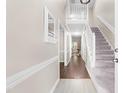Bright foyer features hardwood floors, high ceilings, stairs leading to the upper level, and a view to the living room at 6104 New Market Way, Raleigh, NC 27609