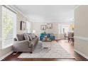 Bright living room features hardwood floors, neutral paint, large windows, and an open layout at 6104 New Market Way, Raleigh, NC 27609