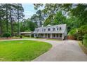Exterior shot of a cozy home with mature trees, well-maintained lawn, and a long driveway at 7009 Brecken Ridge Ave, Raleigh, NC 27615
