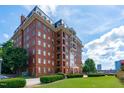 Beautiful brick apartment building with a landscaped lawn, manicured hedges, and charming architectural details at 710 Independence Pl # 301, Raleigh, NC 27603