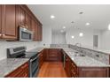Modern kitchen featuring granite countertops, stainless steel appliances, and wooden cabinets with stylish hardware at 710 Independence Pl # 301, Raleigh, NC 27603