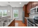 Contemporary kitchen with stainless appliances, granite countertops, hardwood floors, and bright natural lighting at 710 Independence Pl # 301, Raleigh, NC 27603