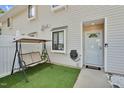 Inviting front porch with cozy swing and artificial turf at 7365 Sandy Creek Dr, Raleigh, NC 27615