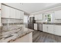 Modern kitchen features stainless steel appliances, granite countertops, and white cabinets at 8116 Bentwood Pl, Raleigh, NC 27615