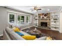 Bright living room with a large bay window, fireplace, built-in shelves, hardwood floors, and a comfortable sofa at 821 Stoneybrook Dr, Sanford, NC 27330