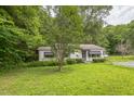 Charming exterior with mature trees, white siding, and a small covered porch at 8635 Old Us 421 S, Bear Creek, NC 27207