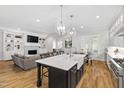 Open-concept living space features an island, built-in shelving, a fireplace, and hardwood floors at 911 Canterbury Rd, Raleigh, NC 27607