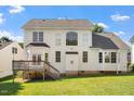 Rear exterior of home with large windows, a wooden deck, and a spacious lawn at 9112 Mission Hills Ct, Raleigh, NC 27617