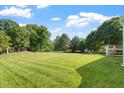 Expansive backyard with lush green grass and mature trees, providing ample space for outdoor activities at 9112 Mission Hills Ct, Raleigh, NC 27617