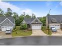 Beautiful gray home with well-manicured front yard, two-car garage and inviting curb appeal at 1010 Sandbar Ln, Durham, NC 27703