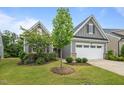 Charming one-story home featuring gray siding, a two-car garage, and manicured landscaping at 1010 Sandbar Ln, Durham, NC 27703