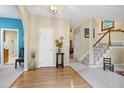 Inviting foyer with hardwood floors, a staircase, and a view into the living room through an archway at 112 Hidden Bluff Ln, Cary, NC 27513