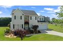 Charming two-story home with an attached garage and beautifully landscaped front yard at 115 Spring Branch Dr, Four Oaks, NC 27524