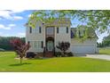 Inviting two-story home featuring a well-manicured lawn and attached two-car garage, creating perfect curb appeal at 115 Spring Branch Dr, Four Oaks, NC 27524