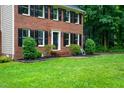 Close-up of a brick home with manicured landscaping and a green lawn at 11816 Stannary Pl, Raleigh, NC 27613