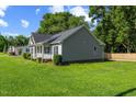 Gray single-story home with black shutters, pretty landscaping, and well-maintained lawn at 12449 W Pamlico St, Middlesex, NC 27557