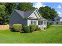 Side view of home showcasing well-maintained landscaping, gray siding, black shutters, and lovely lawn at 12449 W Pamlico St, Middlesex, NC 27557