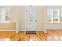 Bright foyer with hardwood floors, white door with decorative glass, and many windows at 1420 Taylor Farm Rd, Raleigh, NC 27603