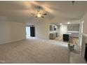 Open-concept living room with view to the kitchen featuring sleek gray cabinets and an island, seamlessly connecting living spaces at 151 Oakfield Trace Dr, Four Oaks, NC 27524