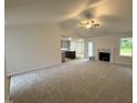 Bright, open-concept living room with a ceiling fan, fireplace, and views of the kitchen creating a welcoming atmosphere at 151 Oakfield Trace Dr, Four Oaks, NC 27524