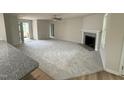 Spacious living room featuring plush carpeting, a ceiling fan, and a cozy fireplace with a mantel at 188 Oakfield Trace Dr, Four Oaks, NC 27524