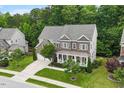 Charming brick home with a covered porch, manicured lawn, and beautiful landscaping offering curb appeal at 213 Preatonwood Dr, Apex, NC 27539