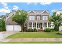 Charming brick home featuring a welcoming front porch and attached two-car garage at 213 Preatonwood Dr, Apex, NC 27539